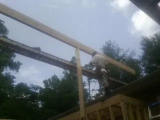 Carpenter setting a ridge beam over a new addition frame — Ice Dam Removal by Roofing Brothers in Sedgwick
