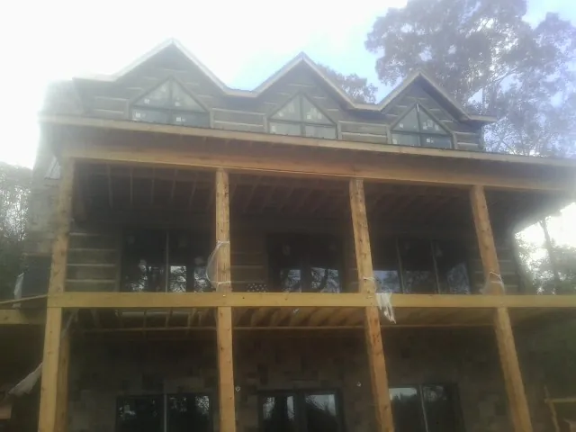 Dormers and porch framing on a large log home under construction — Roof Coating work by our crew in Sedgwick