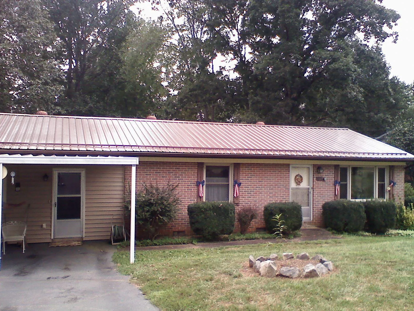 Bronze metal roof and carport on a brick ranch home — Roof Repair work by our crew in Sedgwick